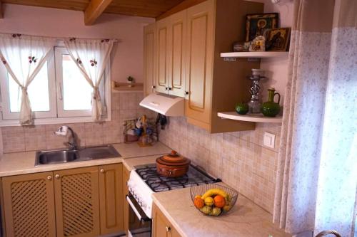 a kitchen with a stove and a bowl of fruit on the counter at Taki's & Anna's in Levkóyia