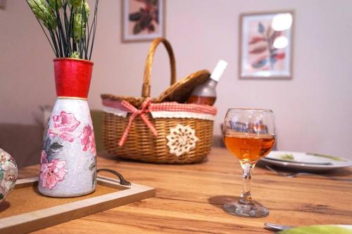 a wooden table with a glass of wine and a basket at Taki's & Anna's in Levkóyia