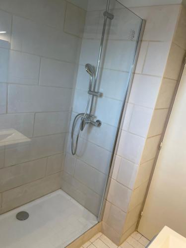 une douche avec une porte vitrée dans une salle de bain dans l'établissement La coquille - Appartement spacieux 45m2, T2 à 1min de la plage - WIFI, à Valras-Plage