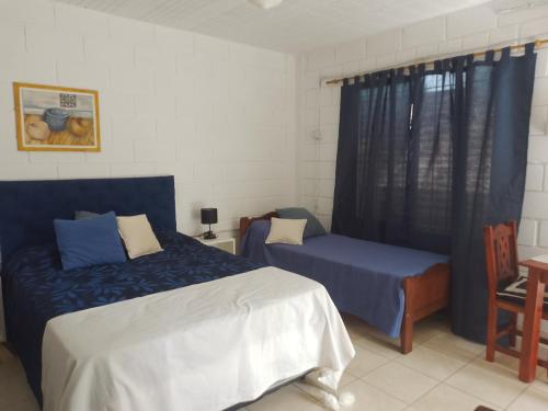 a bedroom with two beds and a chair and a window at El secreto de la vida in Villa de Soto