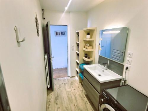 ein Badezimmer mit Waschbecken und Spiegel in der Unterkunft Appartement de standing - coeur de Rezé / 10min de Nantes in Rezé