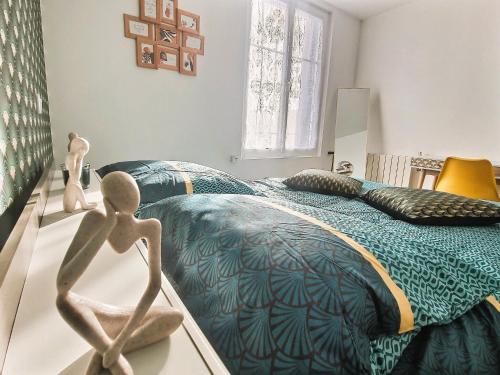 ein Schlafzimmer mit einem Bett mit einer Statue davor in der Unterkunft Appartement de standing - coeur de Rezé / 10min de Nantes in Rezé