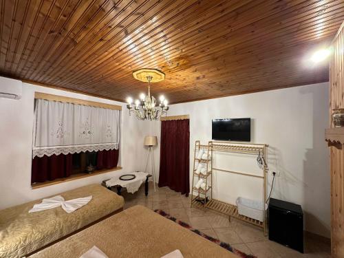 - une chambre avec deux lits et un plafond en bois dans l'établissement "Mani Guest House", à Gjirokastër