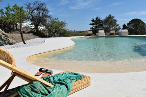 une chaise avec deux tongs à côté de la piscine dans l'établissement Villa Alexandra, à Patmos