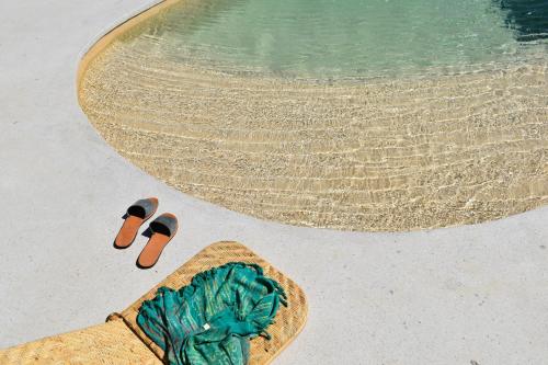 een paar slippers en een mand naast een zwembad bij Villa Alexandra in Patmos