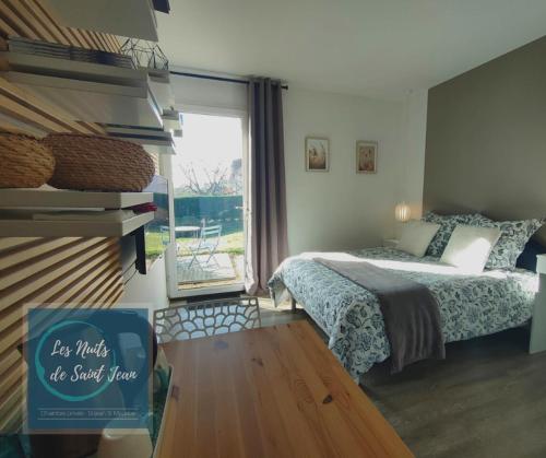 a bedroom with a bed and a window at Les Nuits de Saint Jean in Saint-Jean-Saint-Maurice-sur-Loire