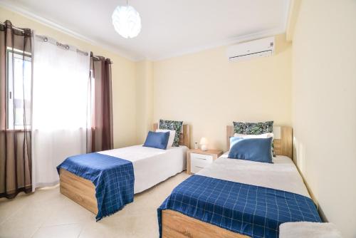 阿爾坎塔里利亞的住宿－Vila com piscina a 5 minutos da Praia，一间卧室设有两张床和窗户。