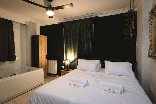 a bedroom with a large white bed with two pillows at Stylish apt w Jacuzzi, 10 min to White Tower in Thessaloniki