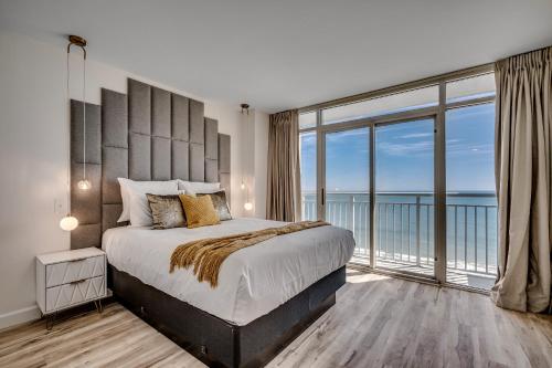 a bedroom with a large bed with a large window at Amazing Newly Renovated Atlantica Condo on the 9th flloor in Myrtle Beach