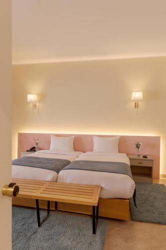a bedroom with two beds and a bench in it at La Siesta Hotel Al Sokhna in Ain Sokhna