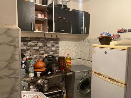 a small kitchen with a stove and a refrigerator at Jolie appartement oulfa azhar in Casablanca
