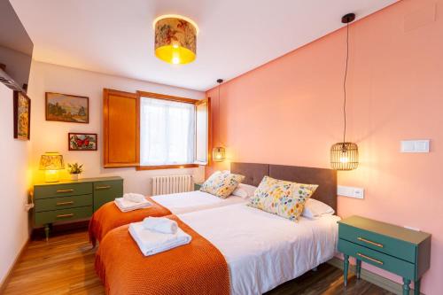 two beds in a bedroom with orange walls at A Casa da Carminha, Ribeira Sacra in Pereiro de Aguiar