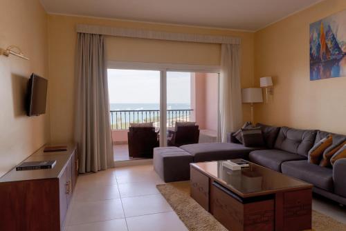 a living room with a couch and a tv at La Siesta Hotel Al Sokhna in Ain Sokhna