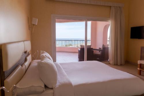 a bedroom with a bed with a view of the ocean at La Siesta Hotel Al Sokhna in Ain Sokhna