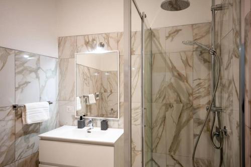 a bathroom with a shower and a sink and a mirror at City Center near the beach in Castelsardo
