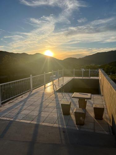 a sunset on a balcony with a table and benches at Duplex Cerró Victoria in Potrero de los Funes
