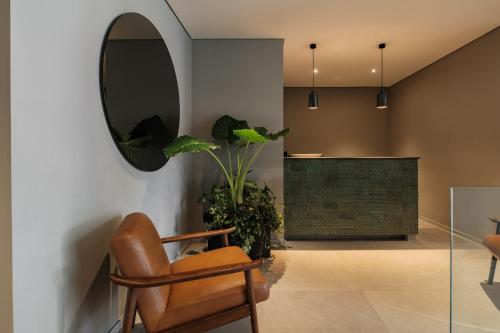 a living room with a chair and a mirror at Casa Cibeles by Lumina in Mexico City
