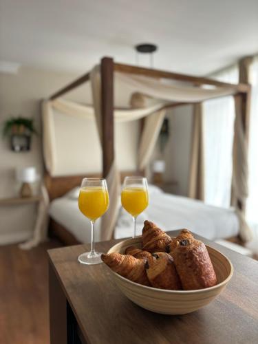 a bowl of bread and two glasses of orange juice at Le Studio Bohème in Saint-Aignan