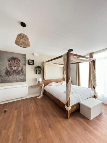a bedroom with a bed and a painting of a lion at Le Studio Bohème in Saint-Aignan