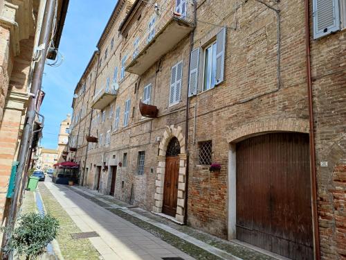 un vicolo in un vecchio edificio di mattoni con porta in legno di Palazzo Trevisani a Porto San Giorgio