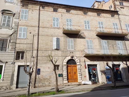 - un vieux bâtiment en briques avec une porte en bois dans l'établissement Palazzo Trevisani, à Porto San Giorgio