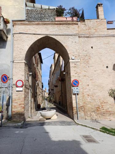 une arche dans un bâtiment en briques avec une rue dans l'établissement Palazzo Trevisani, à Porto San Giorgio