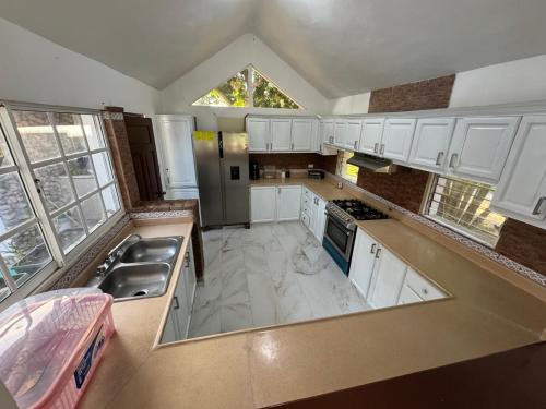 mit Blick auf eine Küche mit weißen Schränken in der Unterkunft Villa Angel in Matanzas