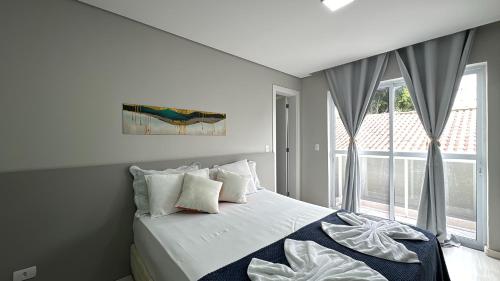 um quarto branco com uma cama e uma janela em 3-Studio lindamente decorado! Ideal para casal!!! em Curitiba