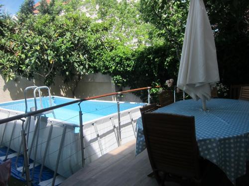 - une table avec un parasol à côté de la piscine dans l'établissement Maison au cœur de Lyon, à Lyon