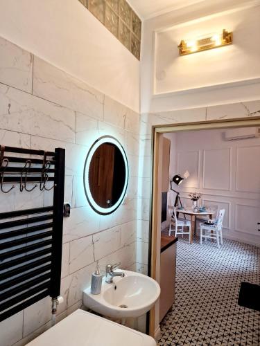 a bathroom with a sink and a mirror and a table at Apartament Kety Rynek Mickiewicza in Kęty
