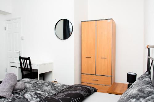 a bedroom with a bed and a desk and a cabinet at Mayfun Rooms Near Teeside Uni in Middlesbrough