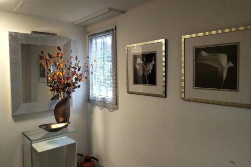 ein Zimmer mit drei Bildern und einer Vase an der Wand in der Unterkunft Vreneli in Mitlödi
