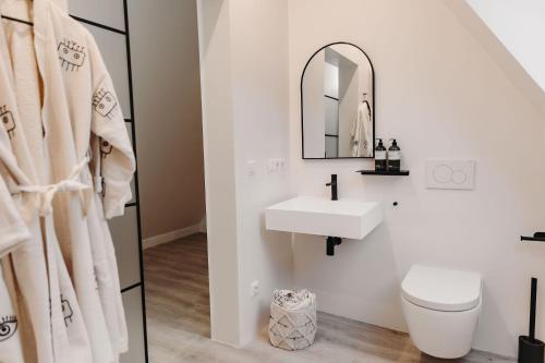 a white bathroom with a sink and a mirror at Individuelle und zentrale Boho Appartments in Coburg in Coburg