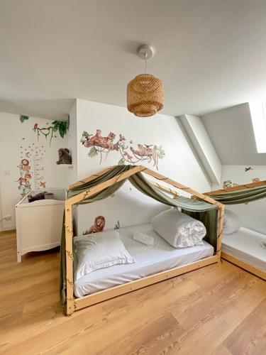 une chambre avec un lit à baldaquin dans l'établissement Le Duplex Safari, à Saint-Aignan
