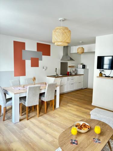 une cuisine et une salle à manger avec une table et des chaises dans l'établissement Le Duplex Safari, à Saint-Aignan