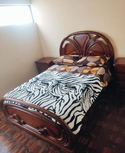a bedroom with a bed with a zebra print blanket at Departamento en Cuenca in Cuenca