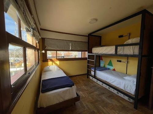 um quarto com 2 beliches e uma janela em Pintó Casa Hostel & Bar em Esquel