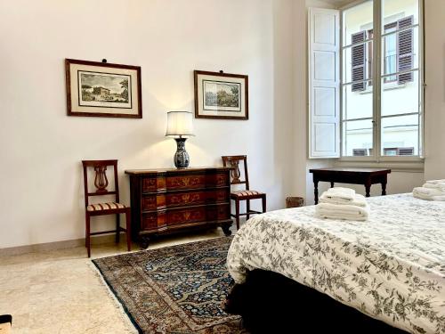 a bedroom with a bed and two chairs and a dresser at Borgia di Firenze in Florence