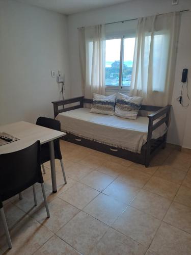 a bedroom with a bed and a table and a window at Departamento Alero in Goya