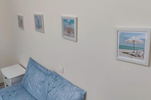 a bedroom with a blue pillow and pictures on the wall at Lovely 1 Bedroom flat w/ WiFi and 5 min from beach in Santa Maria