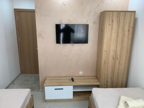 a room with two beds and a television on a wall at Eliksir in Gornja Trepča
