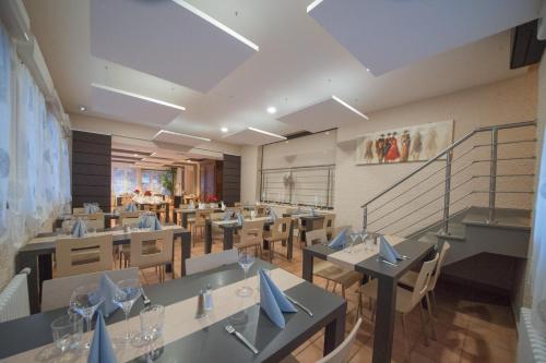 a restaurant with tables and chairs with blue bows at Logis Hôtel Restaurant Barrey in Orchamps-Vennes