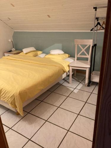 1 dormitorio con 1 cama y 1 silla en B&B Haus Jola en Nidrum