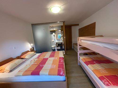 een slaapkamer met 2 bedden en een badkamer bij Apartments Mrakič in Bovec