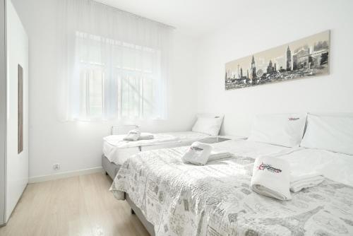 2 camas en una habitación con paredes blancas en ApartamentyPrzyMorzu Strzelecka 33 z parkingiem en Kołobrzeg