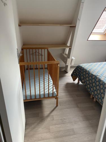 a room with a staircase with a bed and a crib at Appartement en centre ville pour 4 personnes in Roye