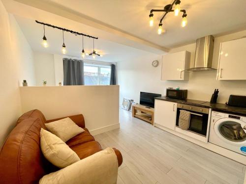 a living room with a couch and a kitchen at April Disc - Long Stay - Contractors in Swindon