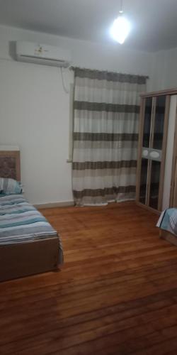 a bedroom with a bed and a wooden floor at شقه امام كلية الطب in Alexandria