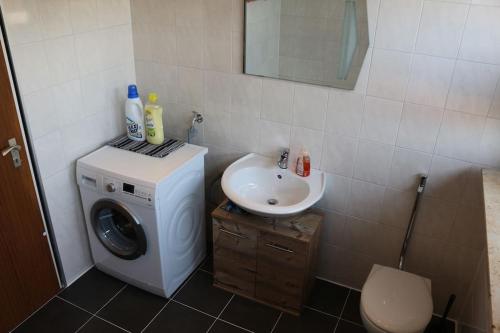 a bathroom with a washing machine and a sink at Apartment Style in Roth in Roth