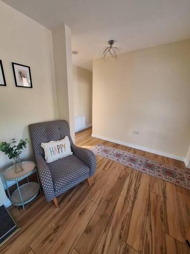 a living room with a chair with a pillow on it at 'Grange Hideaway' Town Centre (Sleeps 6) in Omagh